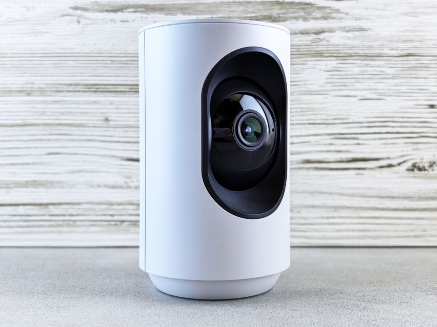 Compact indoor home security camera on a shelf in a rented flat