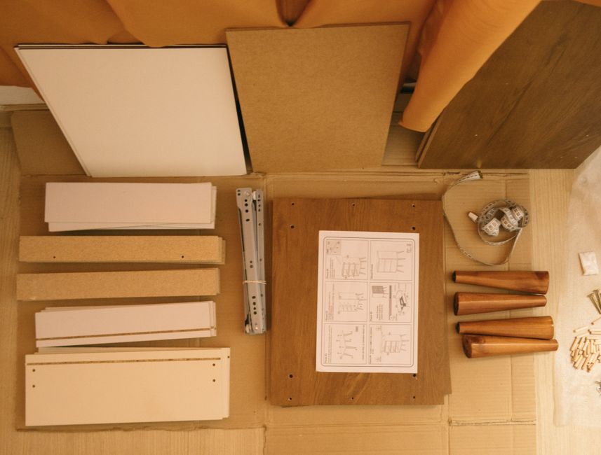 Flat-pack furniture parts and an instruction sheet laid out on the carton before assembly